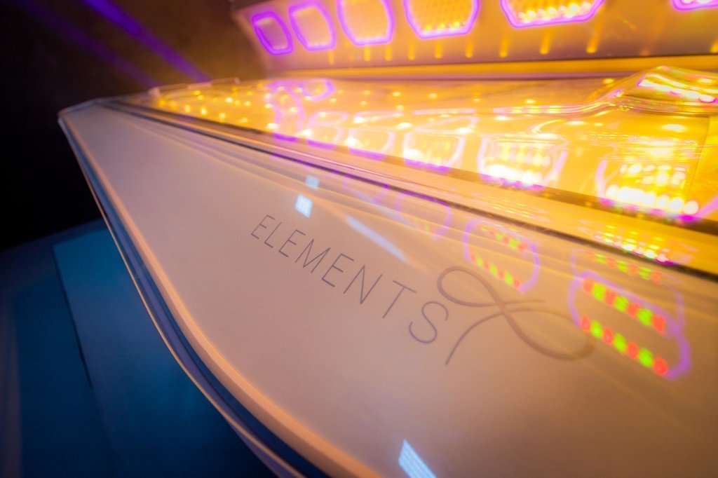 Warm golden LED light inside the Ergoline Elements tanning tunnel